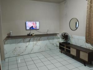 a bathroom with a tv on a counter and a mirror at Casa 2 grande perto do pavilhão de Carapina in Serra