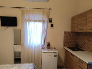 a kitchen with a curtain over a window with a sink at Ζ&Ζ Studios in Perea +36 photos