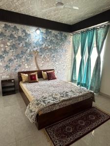 a bedroom with a bed and a wall with blue flowers at Taj Nidhi Luxury in Agra