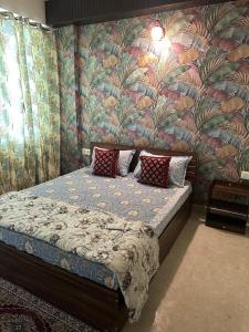 a bedroom with a bed with a floral wall at Taj Nidhi Luxury in Agra