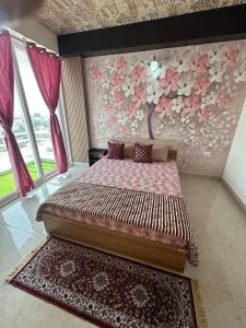 a bedroom with a bed and a wall with flowers at Taj Nidhi Luxury in Agra