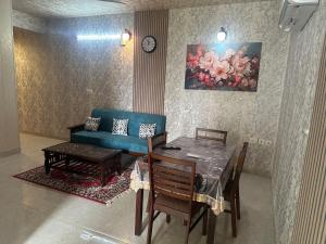 a living room with a table and a blue couch at Taj Nidhi Luxury in Agra +21 photos