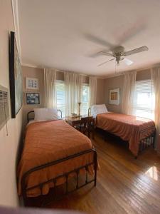 a bedroom with two beds and a ceiling fan at Bright 1BR Hideaway Close to UL Lafayette in Lafayette