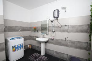a bathroom with a sink and a phone on the wall at Ideal Residence in Matara +25 photos