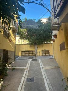 an alley with benches and a tree in the distance at Flower Home in Crotone