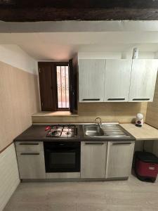 a kitchen with a sink and a stove top oven at Flower Home in Crotone +2 photos