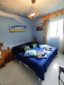 a bedroom with a bed with blue sheets and a window at Vicky's B&B by V in Papasidero +74 photos