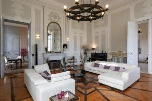 a living room with white furniture and a chandelier at Château Puybarban in Puybarban
