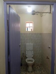 Un baño con un inodoro blanco en una habitación. en Valley View, en Kiambu