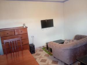 Una sala de estar con un sofá y un televisor de pantalla plana. en Valley View, en Kiambu