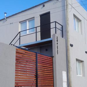 een gebouw met een rode garagedeur en een balkon bij Dpto nuevo frente al Rio in Necochea