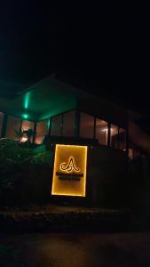 Letrero de aania frente a un edificio por la noche en Essence Arenal Spa & Yoga, en El Castillo de La Fortuna