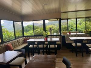 Un restaurante con mesas y sillas y grandes ventanales. en Essence Arenal Spa & Yoga, en El Castillo de La Fortuna 111 fotos más