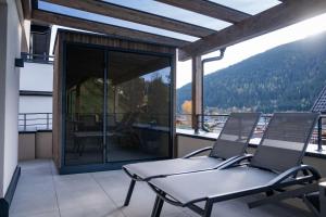 a balcony with two chairs and a view of the mountains at Nestzeit in Eben im Pongau