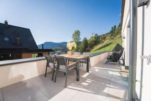 a patio with a table and chairs on a balcony at Nestzeit in Eben im Pongau