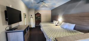 een hotelkamer met twee bedden en een flatscreen-tv bij Regency Inn & Suites By Capital O Houston IAH Airport in Humble +48 foto's