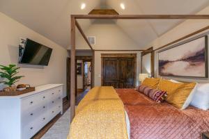 a bedroom with a canopy bed and a tv at Overlook Nook at Eagles Nest in Elk Park