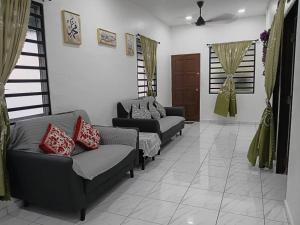 a living room with two couches in a room at Balqis LN Homestay in Taiping