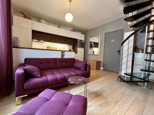 a purple sofa in a living room with a purple couch at Joli Duplex Confort T2 Paris Porte De Versailles in Vanves