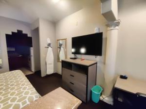 een slaapkamer met een bed en een flatscreen-tv bij Regency Inn & Suites By Capital O Houston IAH Airport in Humble