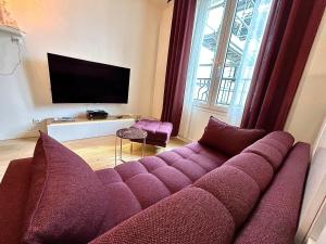 a living room with a purple couch and a tv at Joli Duplex Confort T2 Paris Porte De Versailles in Vanves