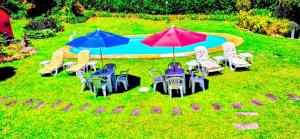 a group of tables and chairs with umbrellas next to a pool at Pousada dos Chalés - Araras in Araras Petropolis