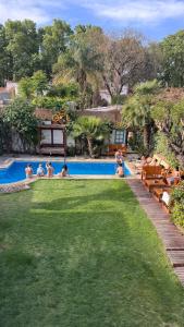 a group of people sitting around a swimming pool at Gorilla Hostel in Mendoza