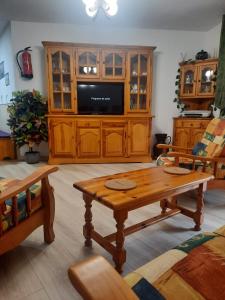 a living room with a tv and a wooden table at Apartamento Picos de Europa in Camaleño