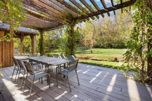 a table and chairs on a patio with a pergola at Whispering Brook in Springdale
