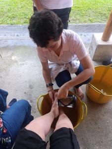 a woman is tying a persons foot in a bag at Agüita con Limón Natural Health in Córdoba