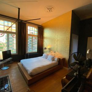 una camera da letto con un letto e una televisione di Lunatree a Mechelen