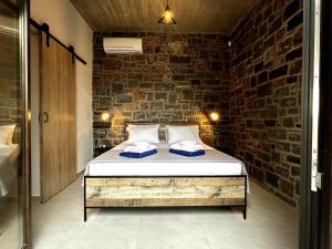 SísionにあるSmall villa with pool DOXA PETRAのレンガの壁にベッド1台が備わるベッドルーム1室