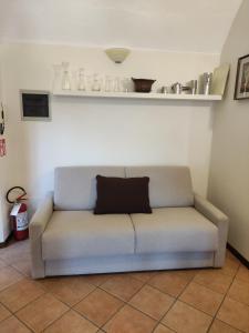 een bank met een kussen op de kamer bij Dimora Fenni - Appartamento elegante nel cuore di Monte Isola con Wi-Fi e aria condizionata in Monte Isola