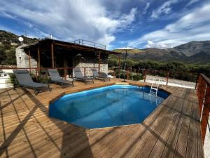 SísionにあるSmall villa with pool DOXA PETRAの家の隣のウッドデッキのスイミングプール