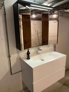 Un baño con un lavabo blanco y un espejo. en Peter Minuit - R36, en Wesel