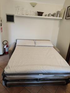 een bed in een kamer naast een muur bij Dimora Fenni - Appartamento elegante nel cuore di Monte Isola con Wi-Fi e aria condizionata in Monte Isola +23 foto's