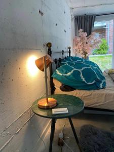 Un dormitorio con una cama y una mesa con una lámpara. en Peter Minuit - R36, en Wesel