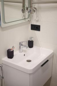a bathroom with a white sink and a mirror at Видова смарт-квартира в ЖК City Park in Cherkasy