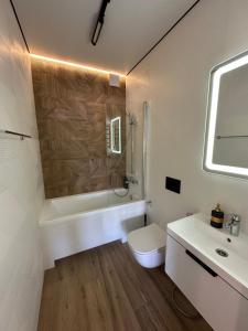 a white bathroom with a toilet and a sink at Видова смарт-квартира в ЖК City Park in Cherkasy