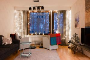 un soggiorno con divano e una finestra con luci di Kitka riverview retreat with sauna a Kuusamo