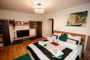 a bedroom with a bed and a flat screen tv at Mony Apartaments in Roman