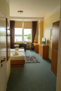 a hotel room with a bed and a window at Seeschloss Hotel Kellersee in Eutin
