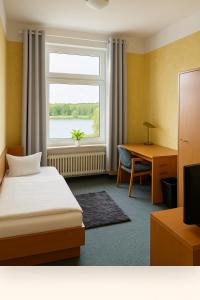 a bedroom with a bed and a desk and a window at Seeschloss Hotel Kellersee in Eutin +1 photo