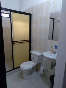 a bathroom with a toilet and a sink at Casa Hotel La Esperanza in Orito