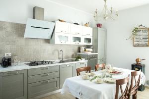 a kitchen with a table with chairs and a sink at Le Bricolle in Viggiù