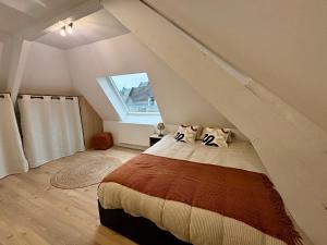 Un dormitorio con una cama en un ático en Le Cocon Arras Centre & Netflix 4 pers, en Arras