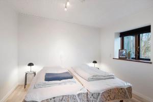 een witte kamer met 2 bedden en een raam bij 80247-Bovlingbjerg-Hovsorevej-16 in Bøvlingbjerg