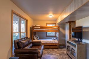 1 dormitorio con literas, sofá y TV en Parkway Hideout, en Boone