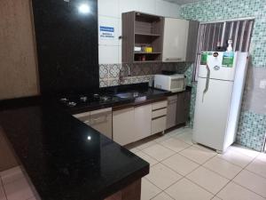 a kitchen with a white refrigerator and a stove at Casa Com Lazer 8 anos in Cidade Ocidental