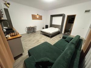 sala de estar con sofá verde y cama en Airport Green, en Cluj-Napoca